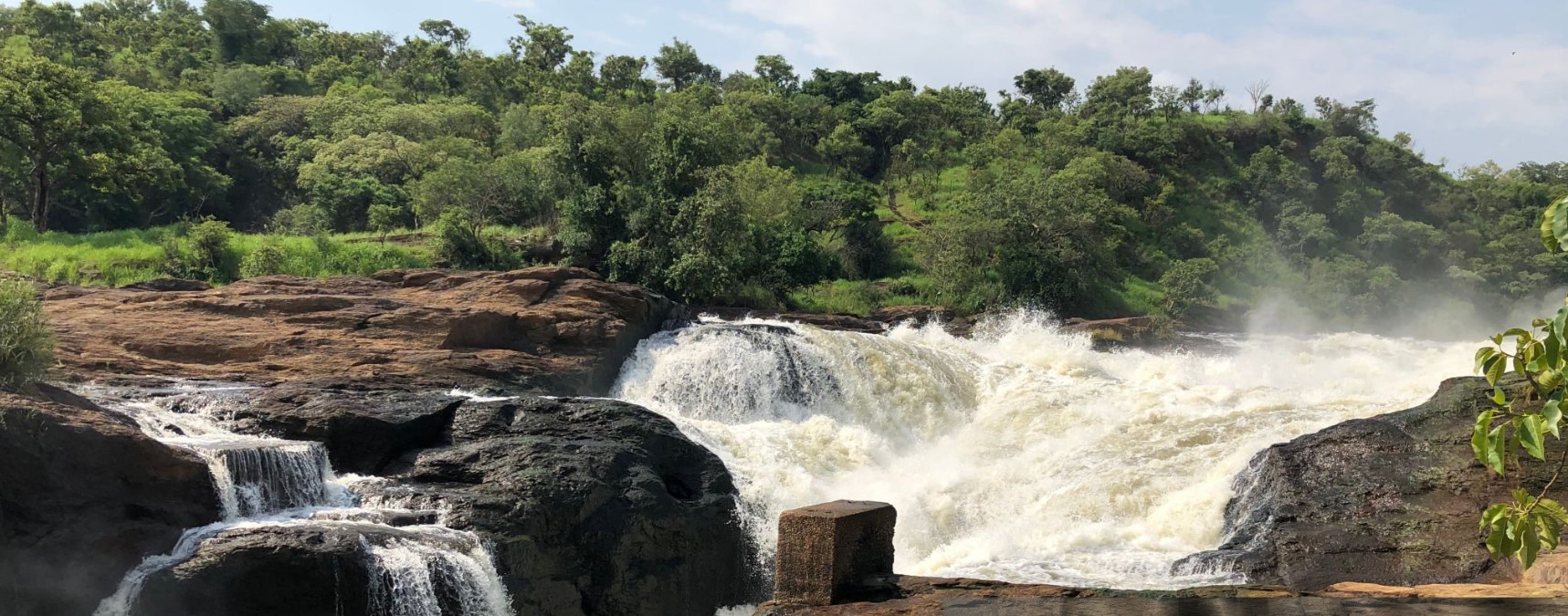 Spectacular view from the top of Murchison Falls in Uganda, with the powerful Nile River plunging through a narrow gorge into misty, churning waters below