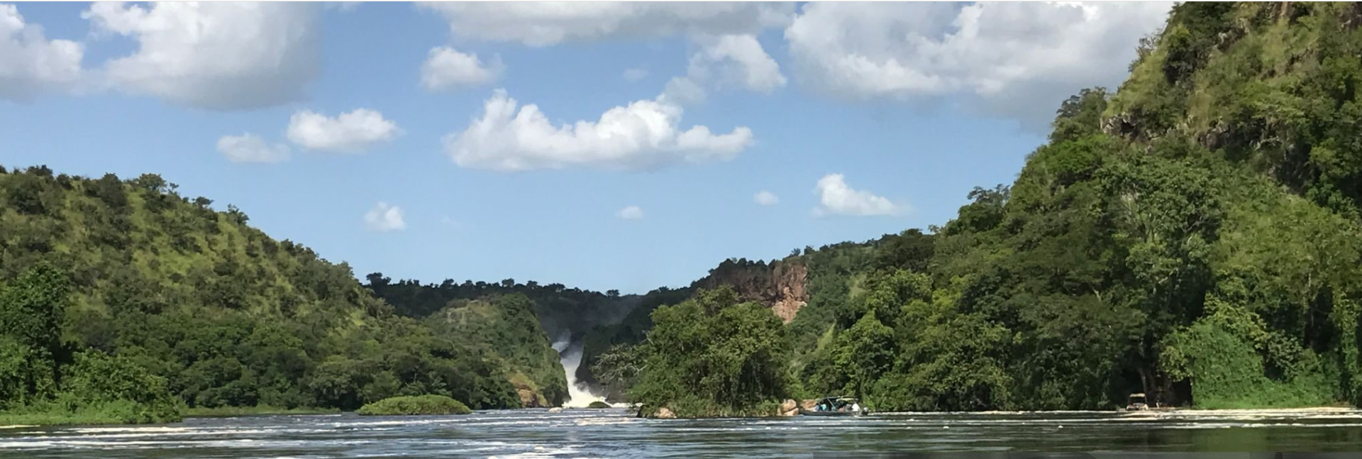 A diverse group of travelers enjoying a 12-day Uganda-Rwanda safari, observing wildlife, exploring national parks, and visiting cultural villages