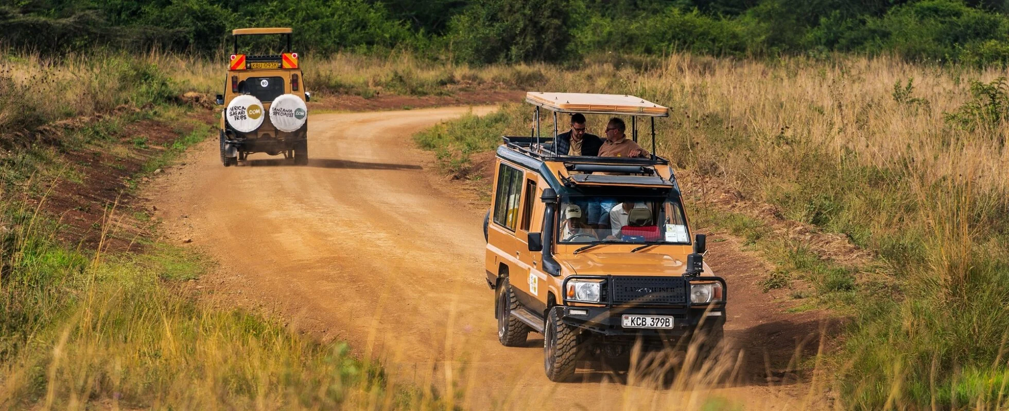 Safari Land Cruiser driving through Tanzania savannah during wildlife game drive.