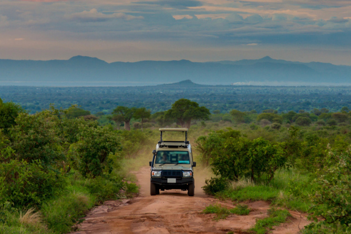 Safari vehicle navigating muddy Tanzania road safely during rainy season adventure.